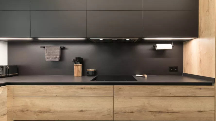 Cocina frente muebles bajos en roble y muebles altos en negro