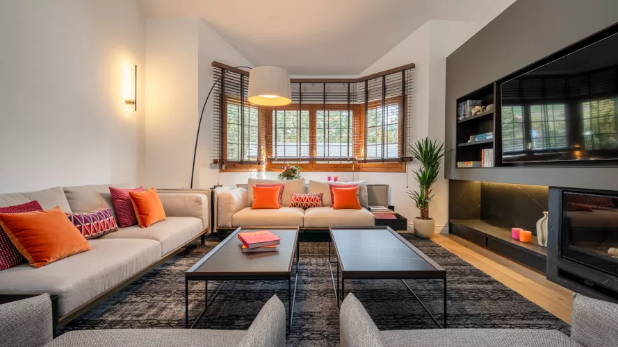 Salón contemporáneo de doble altura con atmósfera cálida y carácter arquitectónico