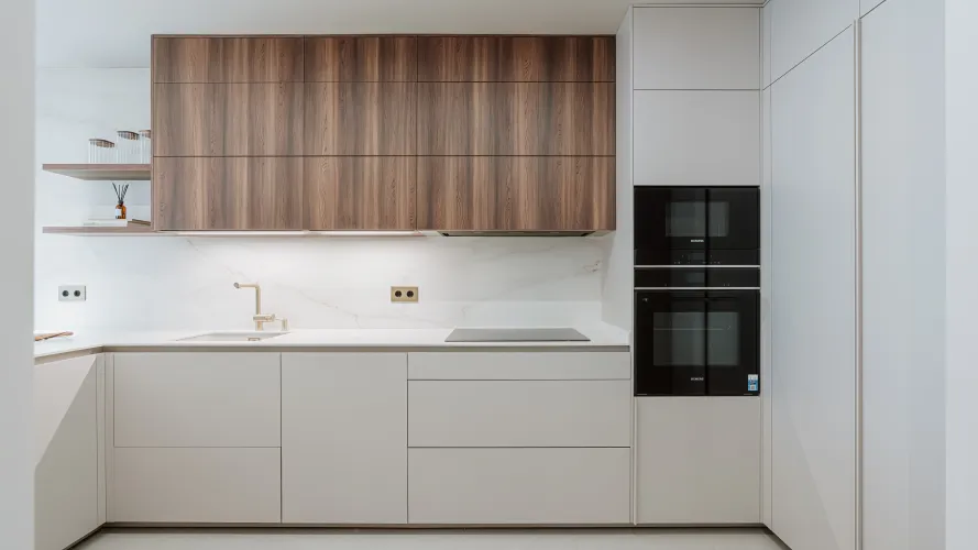 Cocina contemporánea con madera oscura, tonos neutros y detalles dorados