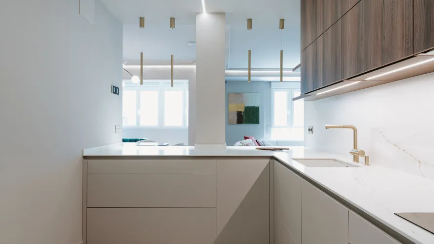 Cocina contemporánea con madera oscura, tonos neutros y detalles dorados
