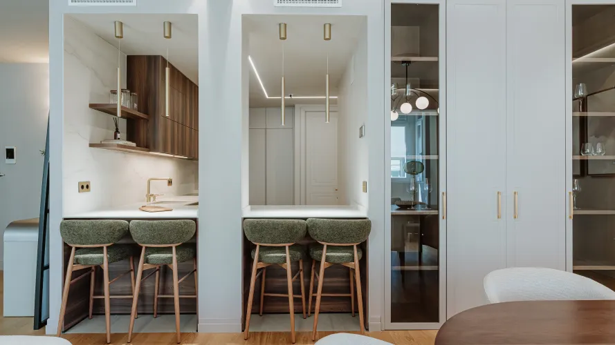 Cocina contemporánea con madera oscura, tonos neutros y detalles dorados