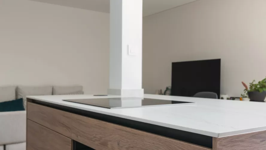 Cocina minimalista, abierta con isla central en tonos cálidos