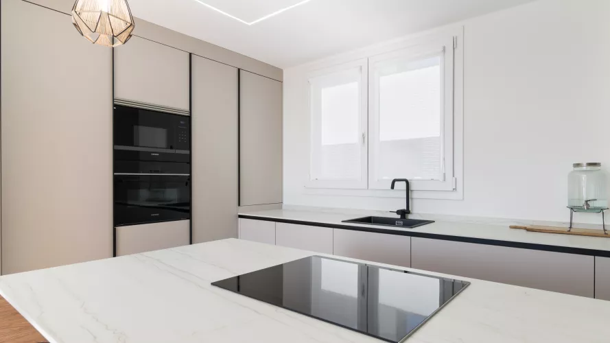 Cocina minimalista, abierta con isla central en tonos cálidos