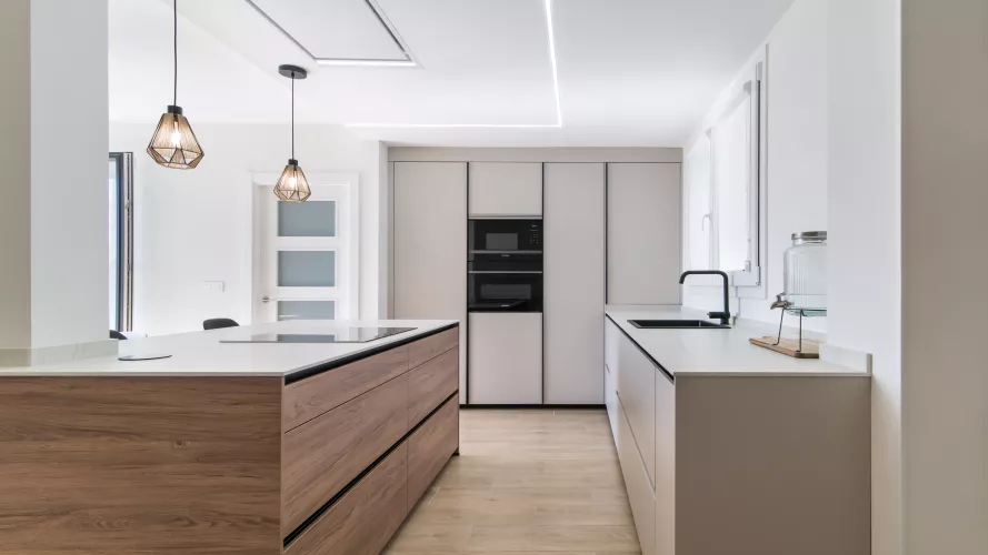 Cocina minimalista, abierta con isla central en tonos cálidos