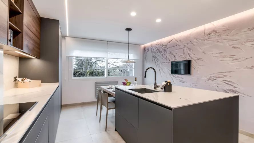 Cocina gris con isla, papel pintado Glamora y lámpara Foscarini