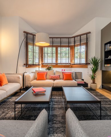 Salón contemporáneo de doble altura con atmósfera cálida y carácter arquitectónico