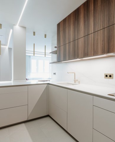 Cocina contemporánea con madera oscura, tonos neutros y detalles dorados
