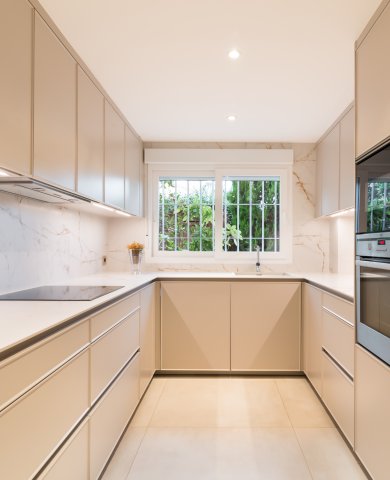 Cocina en U que potencia la luz y la continuidad