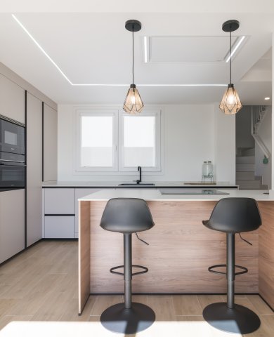 Cocina minimalista, abierta con isla central en tonos cálidos