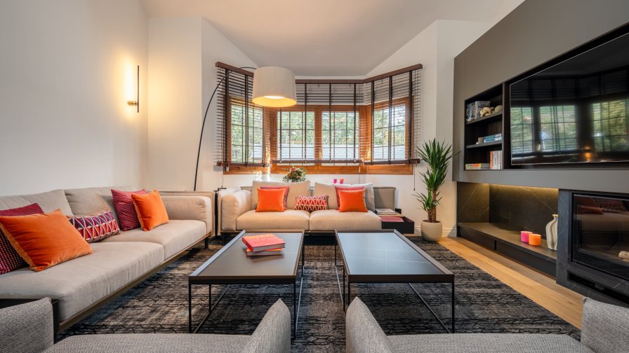 Salón contemporáneo de doble altura con atmósfera cálida y carácter arquitectónico