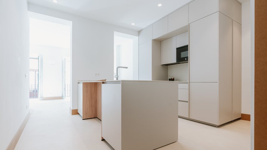 Cocina blanca con isla central y detalles en madera: amplitud, equilibrio y funcionalidad