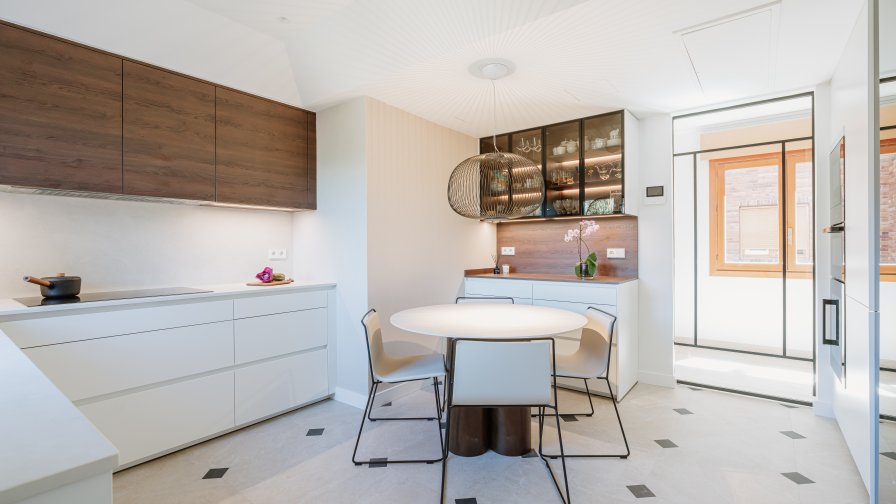 Cocina blanca con madera oscura y vitrinas iluminadas: equilibrio, calidez y funcionalidad