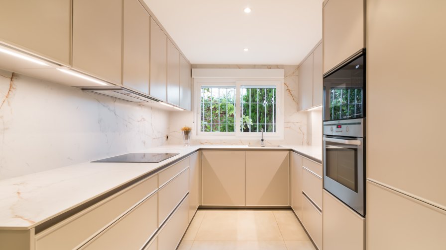 Cocina en U que potencia la luz y la continuidad