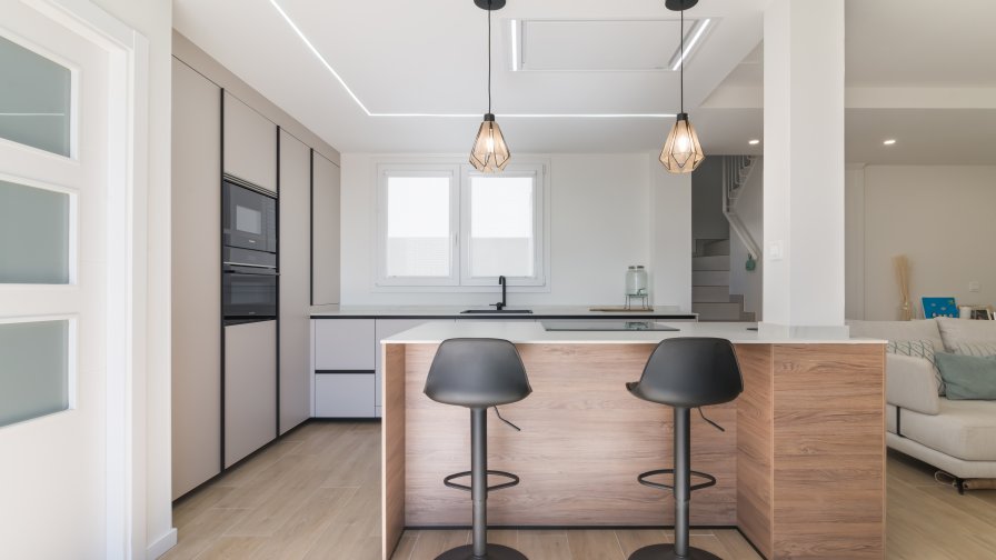 Cocina minimalista, abierta con isla central en tonos cálidos