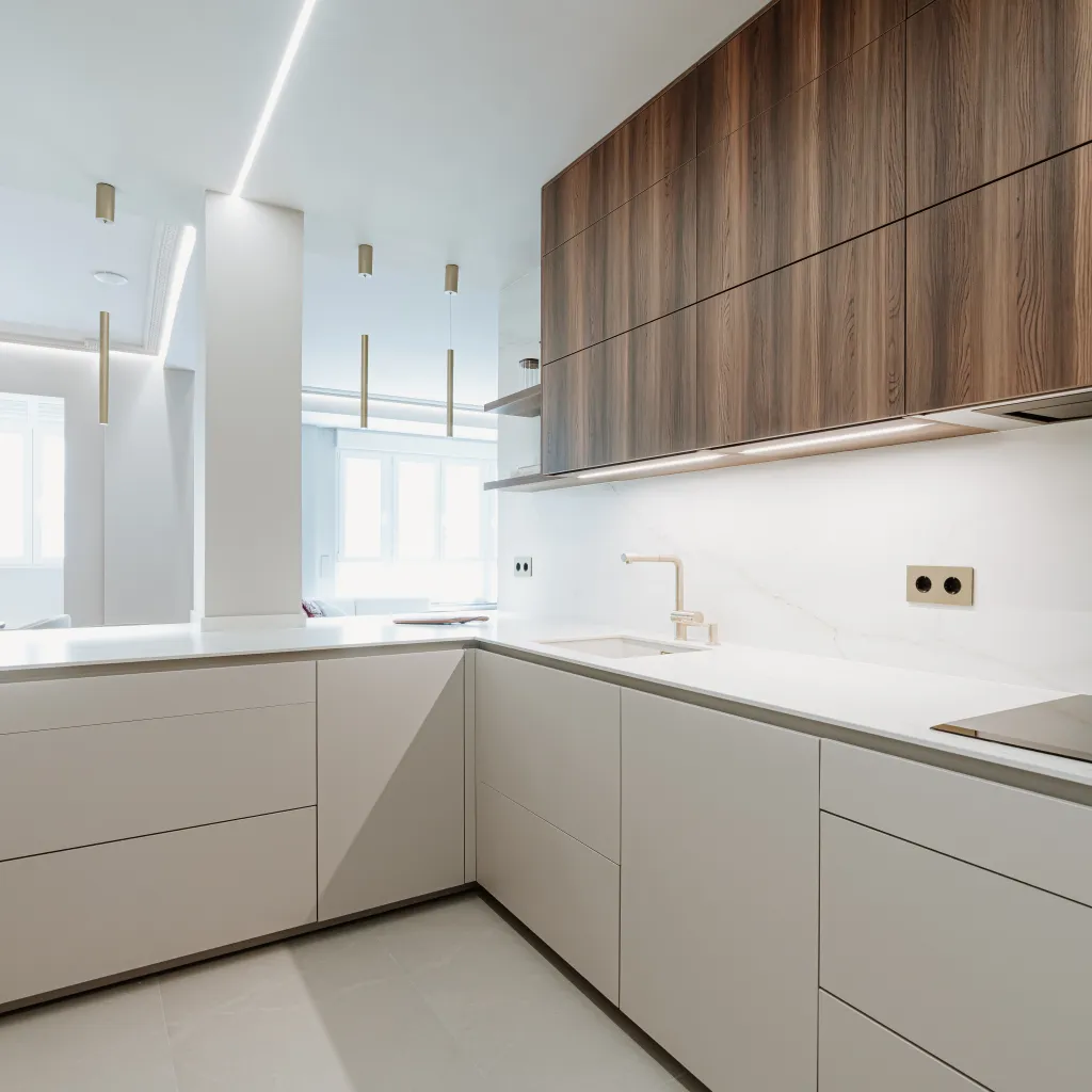 Cocina contemporánea con madera oscura, tonos neutros y detalles dorados