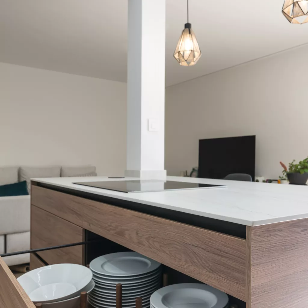 Cocina minimalista, abierta con isla central en tonos cálidos