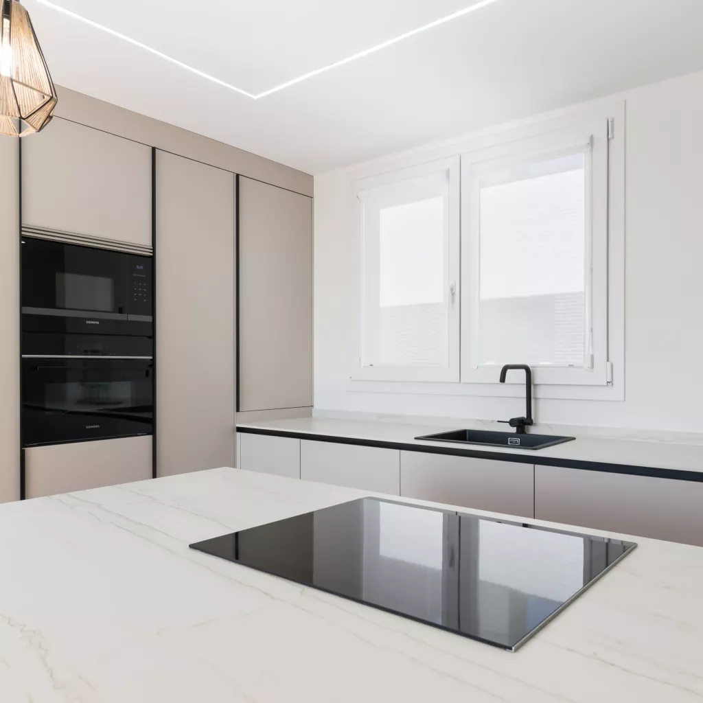 Cocina minimalista, abierta con isla central en tonos cálidos