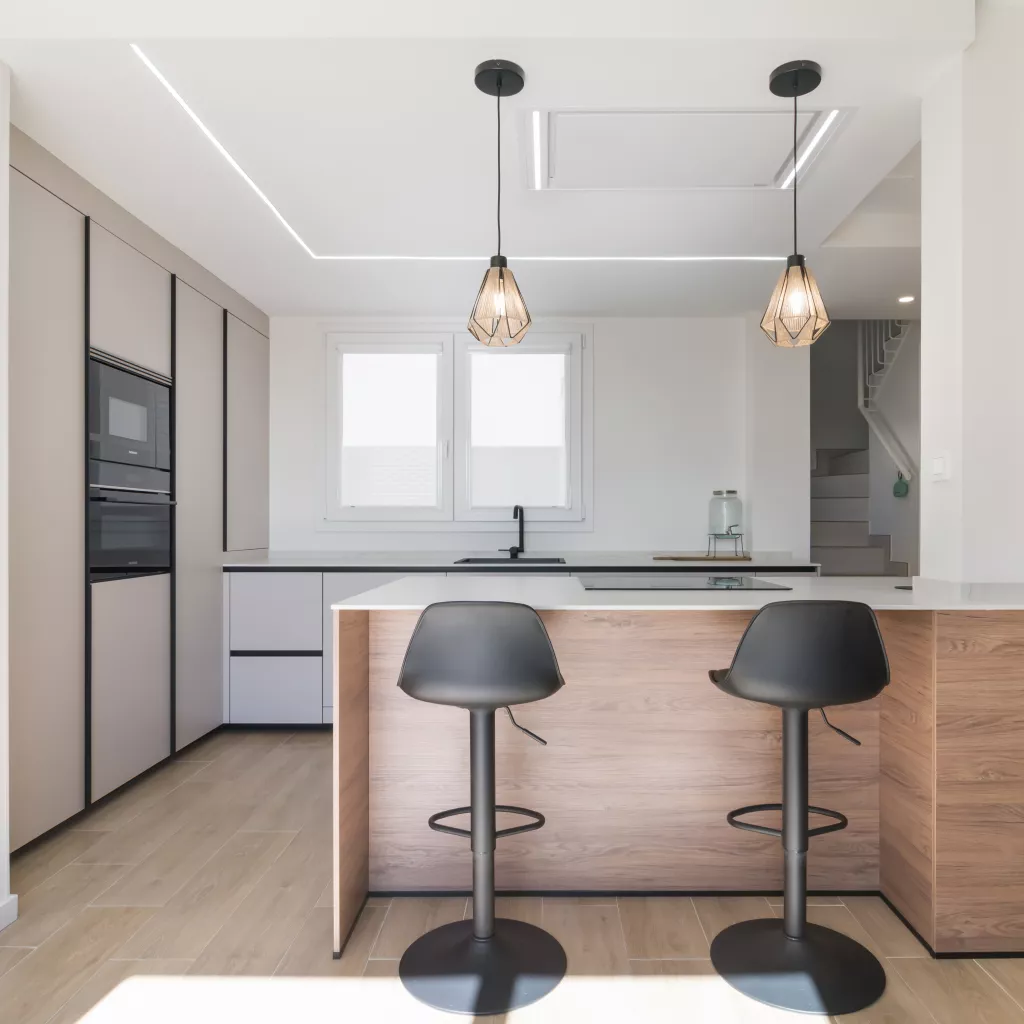 Cocina minimalista, abierta con isla central en tonos cálidos