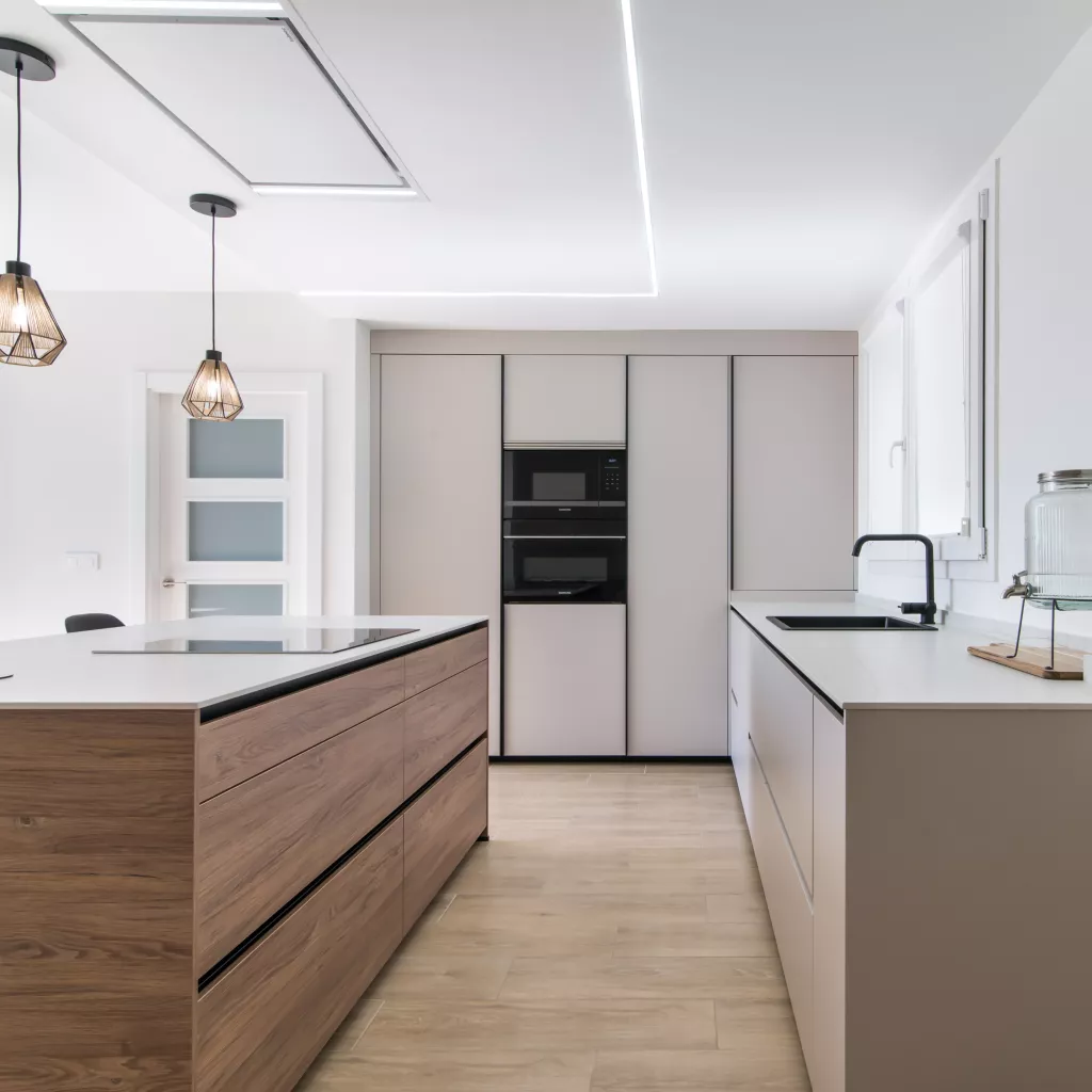 Cocina minimalista, abierta con isla central en tonos cálidos