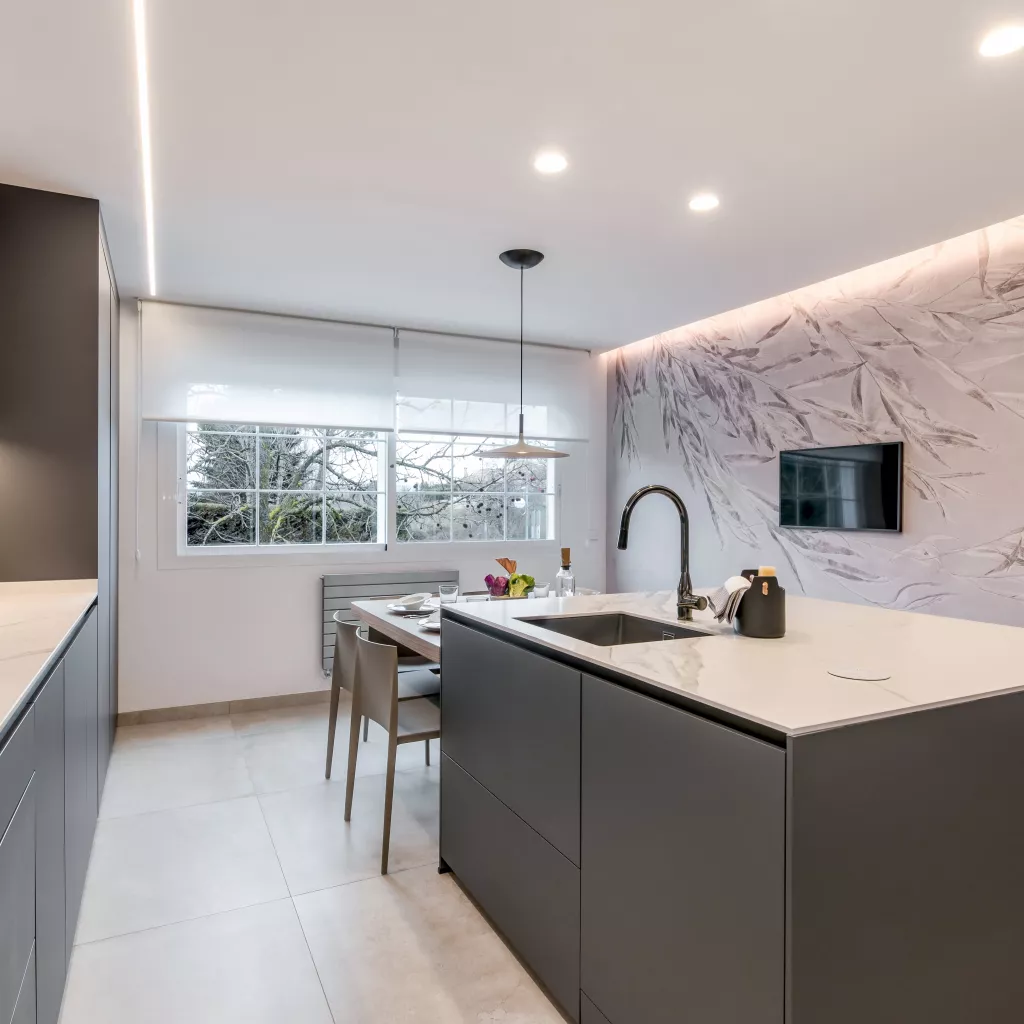 Cocina gris con isla, papel pintado Glamora y lámpara Foscarini