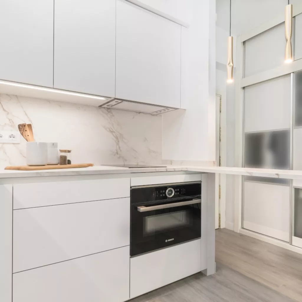 Cocina Santos blanca con barra y encimera Dekton