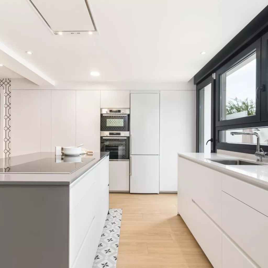 Cocina Santos blanca con isla frente columnas y frente muebles bajos