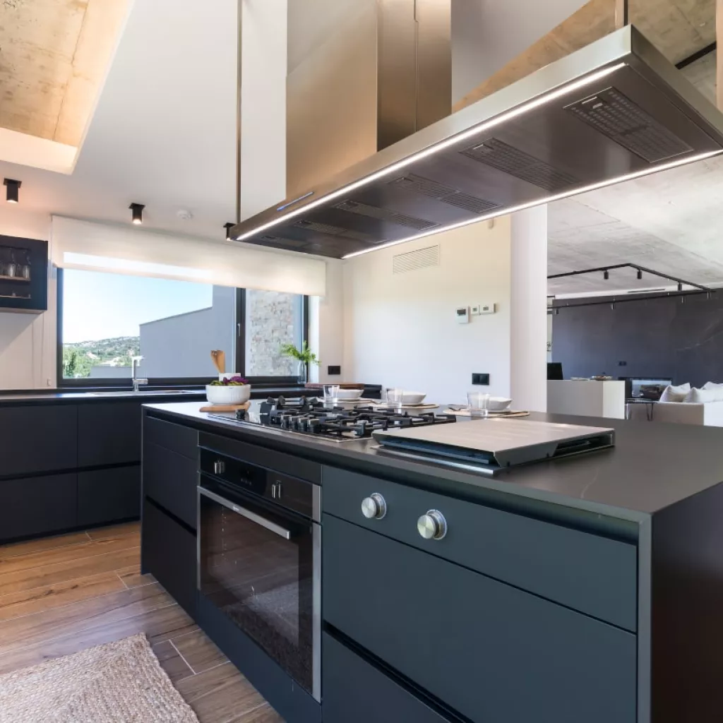 Cocina Santos negra con gran isla zona cocción con placa y parrilla