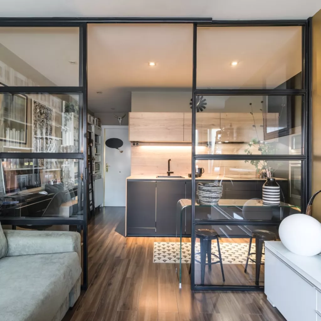 Cocina Santos negra semiabierta a salón con cerramiento cristal y aluminio negro
