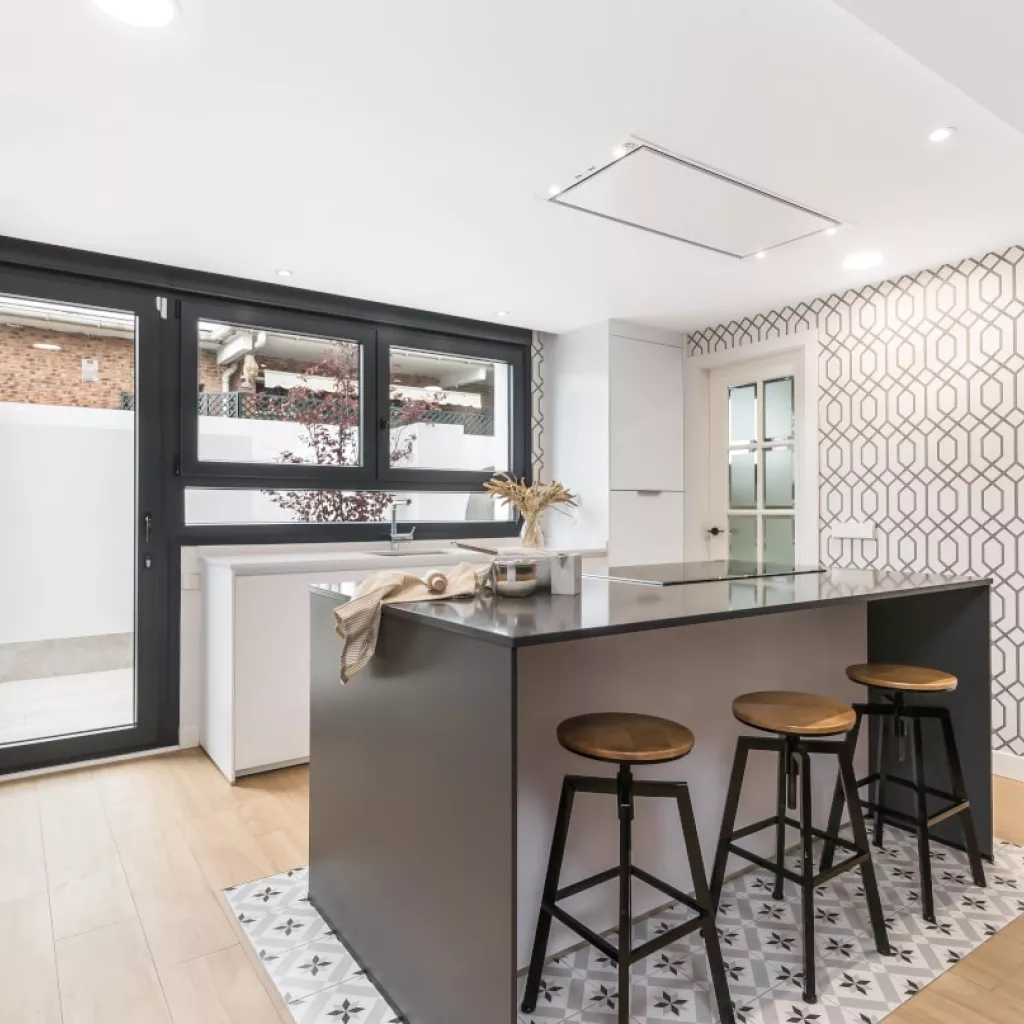 Isla central zona cocción y barra sobre suelo hidráulico